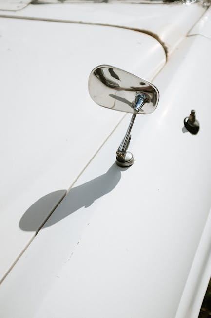 Detailed view of a chrome side mirror on a vintage car, highlighting its classic design.